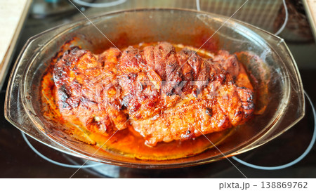 cooking a piece of meat in a glass dish on the stovetop after marinating cooking a piece of meat in a glass dish on the stovetop after marinating 138869762