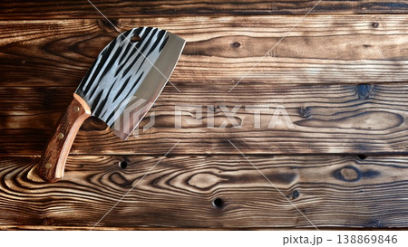Wooden table with zebra-striped cleaver resting on the surface in natural light 138869846
