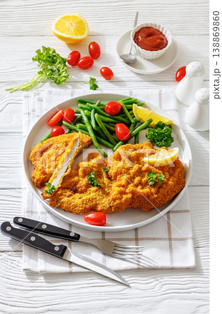 Breaded pork schnitzel with green beans and lemon Breaded pork schnitzel with green beans and lemon 138869860