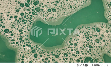 Bubbles form in green liquid during cleaning process near kitchen sink Bubbles form in green liquid during cleaning process near kitchen sink 138870005
