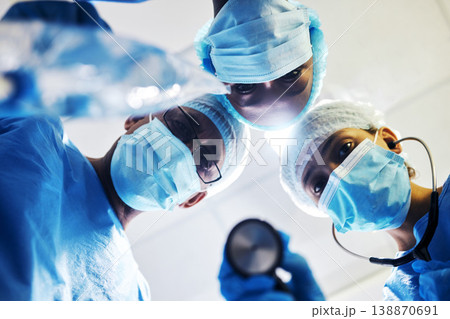 Surgery, medical and a team of doctors in an operating room at the hospital for a medical procedure from patient pov. Face, mask and teamwork with a group of medicine professionals in an operation 138870691