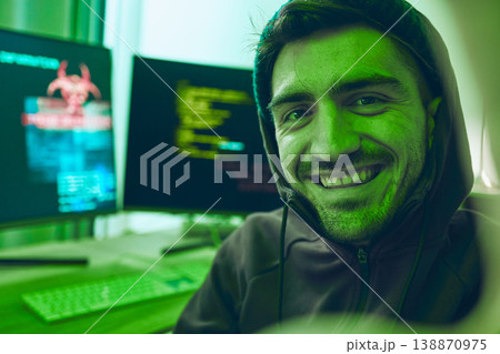 Cybersecurity, crime and smile, portrait of hacker in neon office with code, fraud and virus. Software, ransomware and face of happy man on cyber attack, password thief and online scam with computer. Cybersecurity, crime and smile, portrait of hacker in neon office with code, fraud and virus. Software, ransomware and face of happy man on cyber attack, password thief and online scam with computer. 138870975