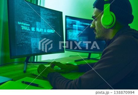 Cyber, gaming and a man with a computer for hacking, streaming music or working on phishing. Serious, dark and a hacker or gamer with a website or information on a pc for a network or privacy 138870994