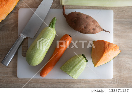 Fresh vegetables on cutting board with zucchini carrot potato and pumpkin Fresh vegetables on cutting board with zucchini carrot potato and pumpkin 138871127