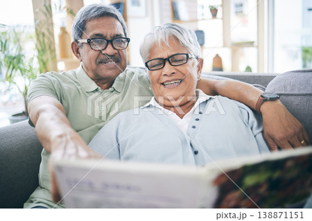 Couple, talking and reading book together on sofa in living room with love, relax and quality time. Senior man, happy woman or partner with glasses, discussion or books on couch at home in retirement 138871151