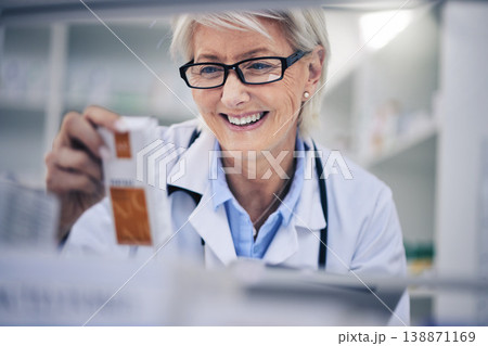 Happy woman, pharmacist and reading medication on shelf for inventory, diagnosis or prescription at pharmacy. Mature female person, medical or healthcare professional checking medicine in drugstore 138871169