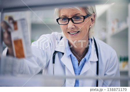 Senior woman, pharmacist and reading medication on shelf for inventory, diagnosis or prescription at pharmacy. Happy mature female person, medical or healthcare professional checking medicine in shop 138871170