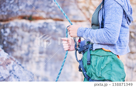 Rock climbing, mountain and hands of woman with rope for adventure, freedom and extreme sports. Fitness, outdoor and female person with safety equipment or gear closeup for training and challenge Rock climbing, mountain and hands of woman with rope for adventure, freedom and extreme sports. Fitness, outdoor and female person with safety equipment or gear closeup for training and challenge 138871349