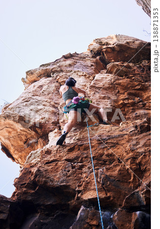 Rock climbing, travel and mountains with woman in nature for sports, explore and adventure. Health, exercise and fitness with person training on cliff for rope, challenge and performance Rock climbing, travel and mountains with woman in nature for sports, explore and adventure. Health, exercise and fitness with person training on cliff for rope, challenge and performance 138871353