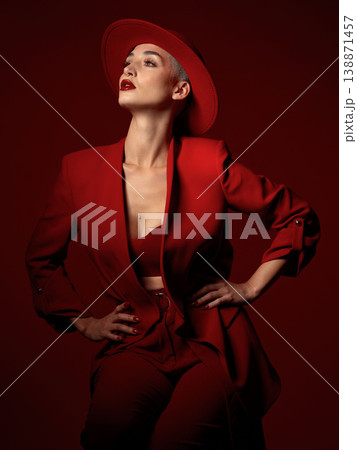 Confident, fashion and a model woman on a red studio background for elegant or trendy style. Aesthetic, art and beauty with a young female person standing hands on hips in an edgy or classy suit Confident, fashion and a model woman on a red studio background for elegant or trendy style. Aesthetic, art and beauty with a young female person standing hands on hips in an edgy or classy suit 138871457
