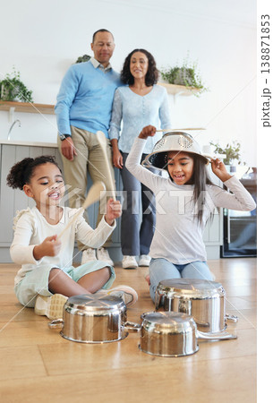 Funny, playing and children with pots for drums with parents watching with love in their home kitchen. Family, happy and crazy playful siblings making noise on metal to play a sound for mom and dad 138871853