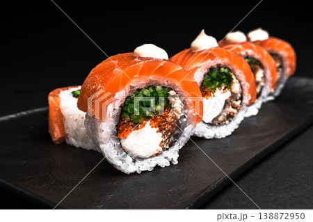 Delicious Fresh Salmon Sushi Rolls Presenting Exquisitely on a Black Background 138872950