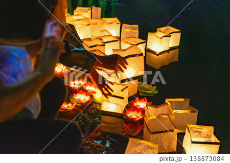 Hands holding glowing paper lanterns, night festival, warm light illuminating scene, creating soft contrast against dark background in cultural celebration. Light ritual, night festival with lantern Hands holding glowing paper lanterns, night festival, warm light illuminating scene, creating soft contrast against dark background in cultural celebration. Light ritual, night festival with lantern 138873084