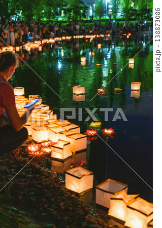 Water lantern festival scene with floating paper lanterns on river surface creating light reflection at night with people releasing candles, cultural ceremony water lantern festival Water lantern festival scene with floating paper lanterns on river surface creating light reflection at night with people releasing candles, cultural ceremony water lantern festival 138873086