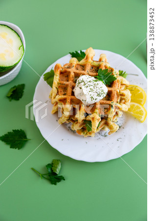 vegetable waffles with zucchini herbs and creamy sauce on top vegetable waffles with zucchini herbs and creamy sauce on top 138873452
