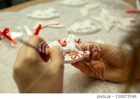 Crafting decorative white and red christmas ornaments by hand 138873596