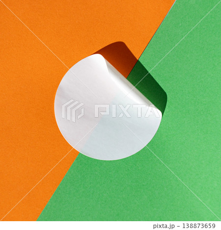 Abstract minimalist design with white paper circle on orange and green background Abstract minimalist design with white paper circle on orange and green background 138873659