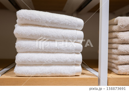 White towels stacked and folded on wooden retail shelf White towels stacked and folded on wooden retail shelf 138873691