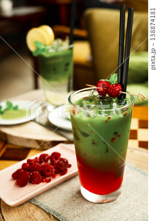 Frozen matcha in the glass with fresh raspberry juice, decorated with fresh natural raspberries. Standing on the wooden coffee table 138874181