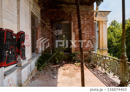 Graffiti walls contrast with rusted structures and lush plants 138874403