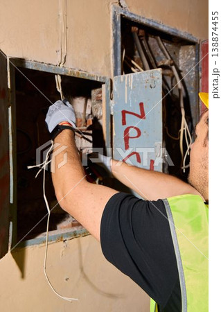 Professional repairing electrical cord in confined industrial space Professional repairing electrical cord in confined industrial space 138874455