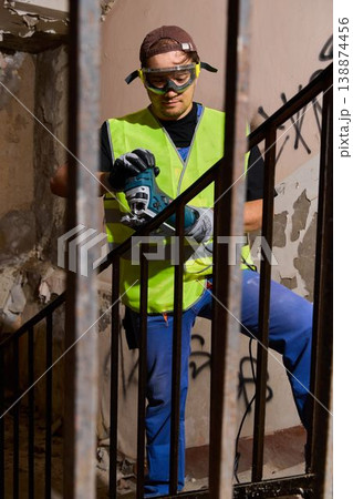 Demolition specialist cutting old railing with power tool Demolition specialist cutting old railing with power tool 138874456