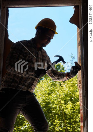 Construction professional inspects transparent surface within foliage Construction professional inspects transparent surface within foliage 138874464