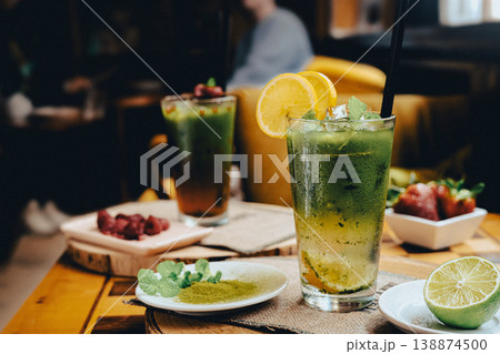 Frozen lemon tea with added matcha in a glass, standing on a wooden table in a cafe Frozen lemon tea with added matcha in a glass, standing on a wooden table in a cafe 138874500