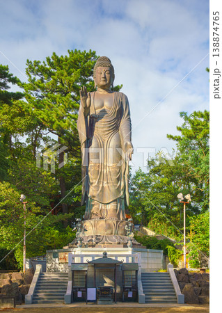 Sakata, Yamagata, Japan - Oct 5 2024, A vertical view of the giant Great Buddha statue at Jichi-In Temple, with trees in the background, at daytime, Sakata, Japan Sakata, Yamagata, Japan - Oct 5 2024, A vertical view of the giant Great Buddha statue at Jichi-In Temple, with trees in the background, at daytime, Sakata, Japan 138874765