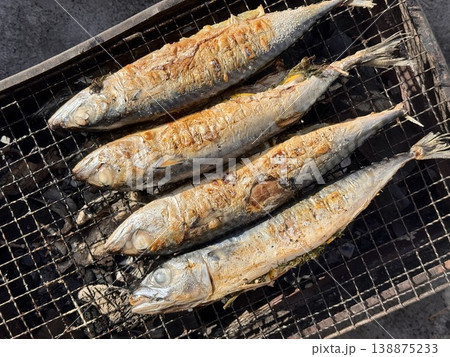 the process of roasting juicy and spiced fresh mackerel on a grill, mackerel on coals on a grill recipe 138875233