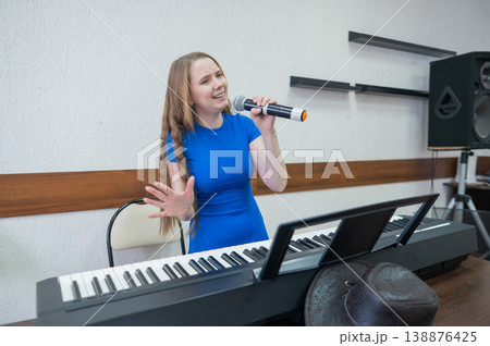 Caucasian woman singing into microphone. Caucasian woman singing into microphone. 138876425