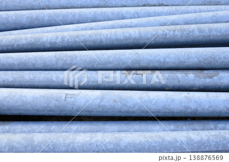 Galvanized steel lighting columns stacked at a construction site. Gray metal poles for street illumination Galvanized steel lighting columns stacked at a construction site. Gray metal poles for street illumination 138876569