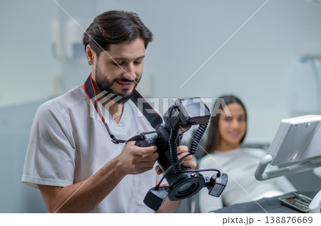 Male doctor checking photo results and looking contented Male doctor checking photo results and looking contented 138876669