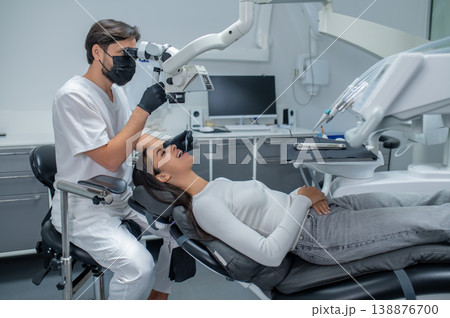 Male dental surgeon working with a female patient and looking concentrated 138876700
