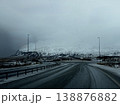 Winding highway leading to snow-capped mountains under a moody sky, Iceland. 138876882