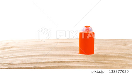 Bottle of sunscreen cream on sand beach isolated on a white background. Bottle of sunscreen cream on sand beach isolated on a white background. 138877029