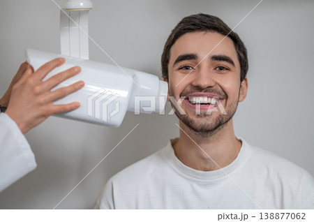 Patient smiling during dental x-ray examination Patient smiling during dental x-ray examination 138877062