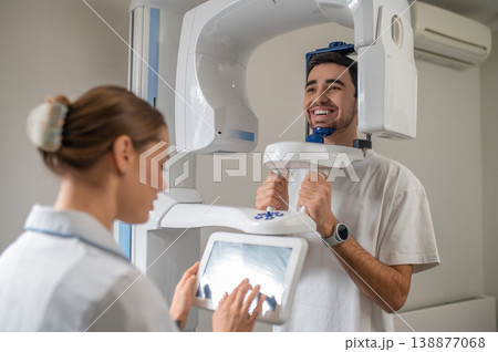 Patient undergoing panoramic dental x-ray scan Patient undergoing panoramic dental x-ray scan 138877068
