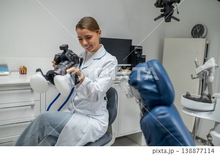 Female dentist holding professional camera with flash 138877114