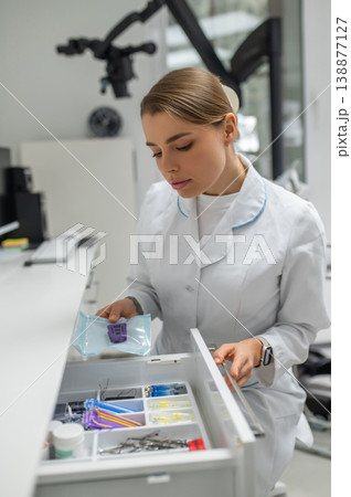 Female doctor taking sterile instrument 138877127