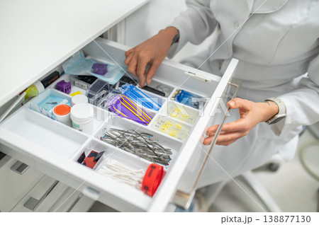 Female assistant opening drawer with supplies 138877130