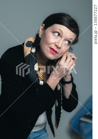 Portrait of attractive young business woman at home with collected dark hair placing her earrings. Portrait of attractive young business woman at home with collected dark hair placing her earrings. 138877227