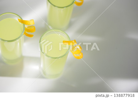Limoncello Glasses with Curled Lemon Peels. Refreshing Summer Italian Beverage Limoncello Glasses with Curled Lemon Peels. Refreshing Summer Italian Beverage 138877918