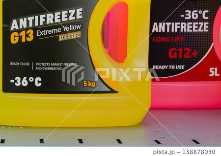 Colorful antifreeze containers G13 and G12 on shelf showing labels and automotive coolant specs Colorful antifreeze containers G13 and G12 on shelf showing labels and automotive coolant specs 138878030