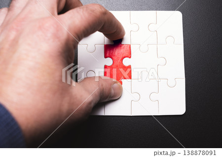A hand is trying to solve a puzzle with a red piece missing A hand is trying to solve a puzzle with a red piece missing 138878091