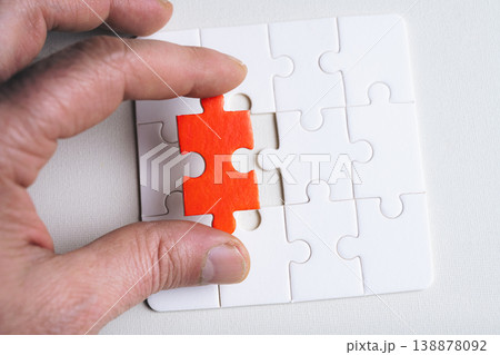 Person hand holds a red jigsaw puzzle piece. Person hand holds a red jigsaw puzzle piece. 138878092