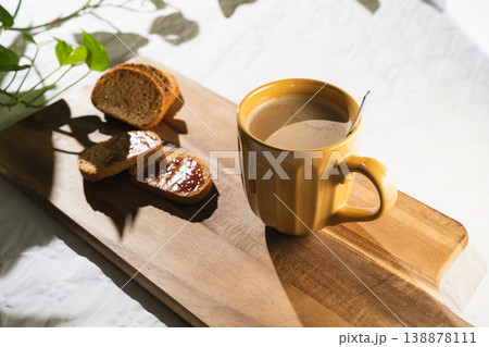 Cup of coffee with milk and toast with jam on wooden board. Breakfast Toast with Coffee. Cup of coffee with milk and toast with jam on wooden board. Breakfast Toast with Coffee. 138878111