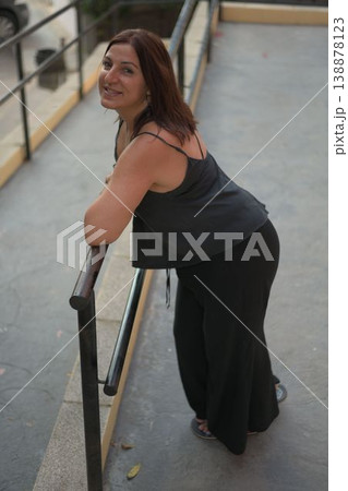 Warm smile, casual pose, leaning on railing 138878123