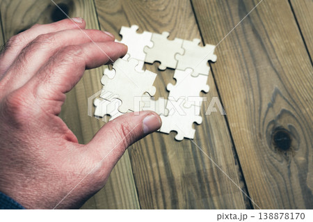A hand is holding a puzzle piece that is missing A hand is holding a puzzle piece that is missing 138878170