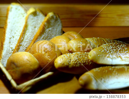 Long sesame buns, round rolls and sliced bread in wicker basket 138878353